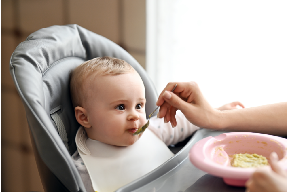 Baby eating vegetable puree from spouted pouch from RubeeFlex Packaging