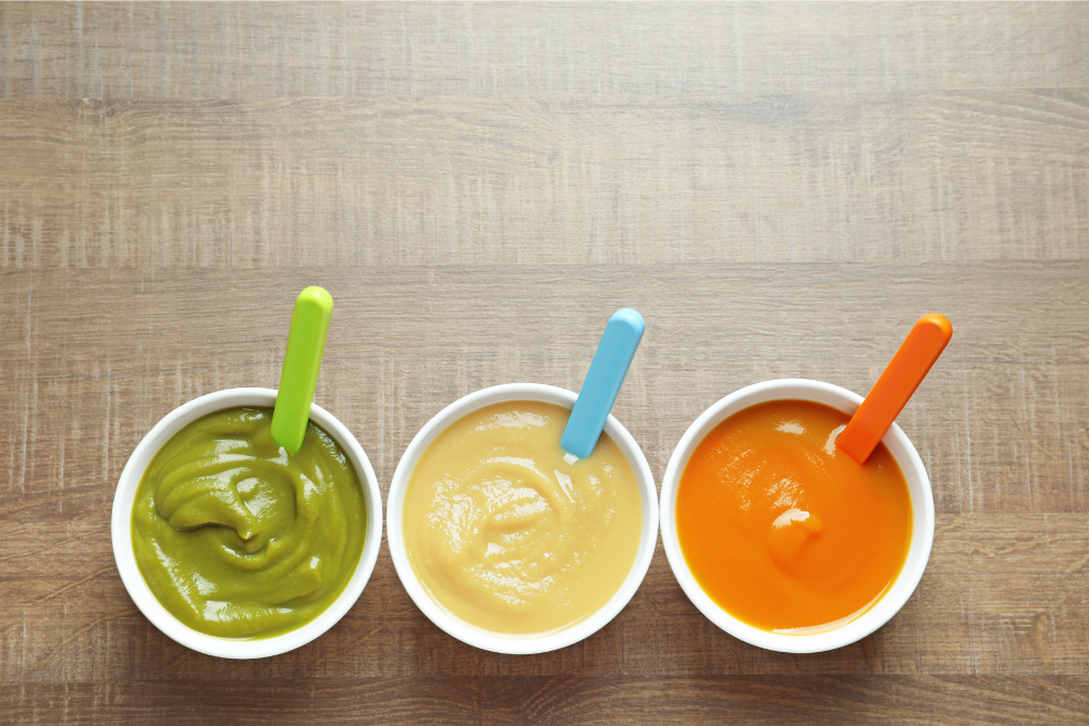 Bowls of pureed baby food in different colors from RubeeFlex spouted pouches